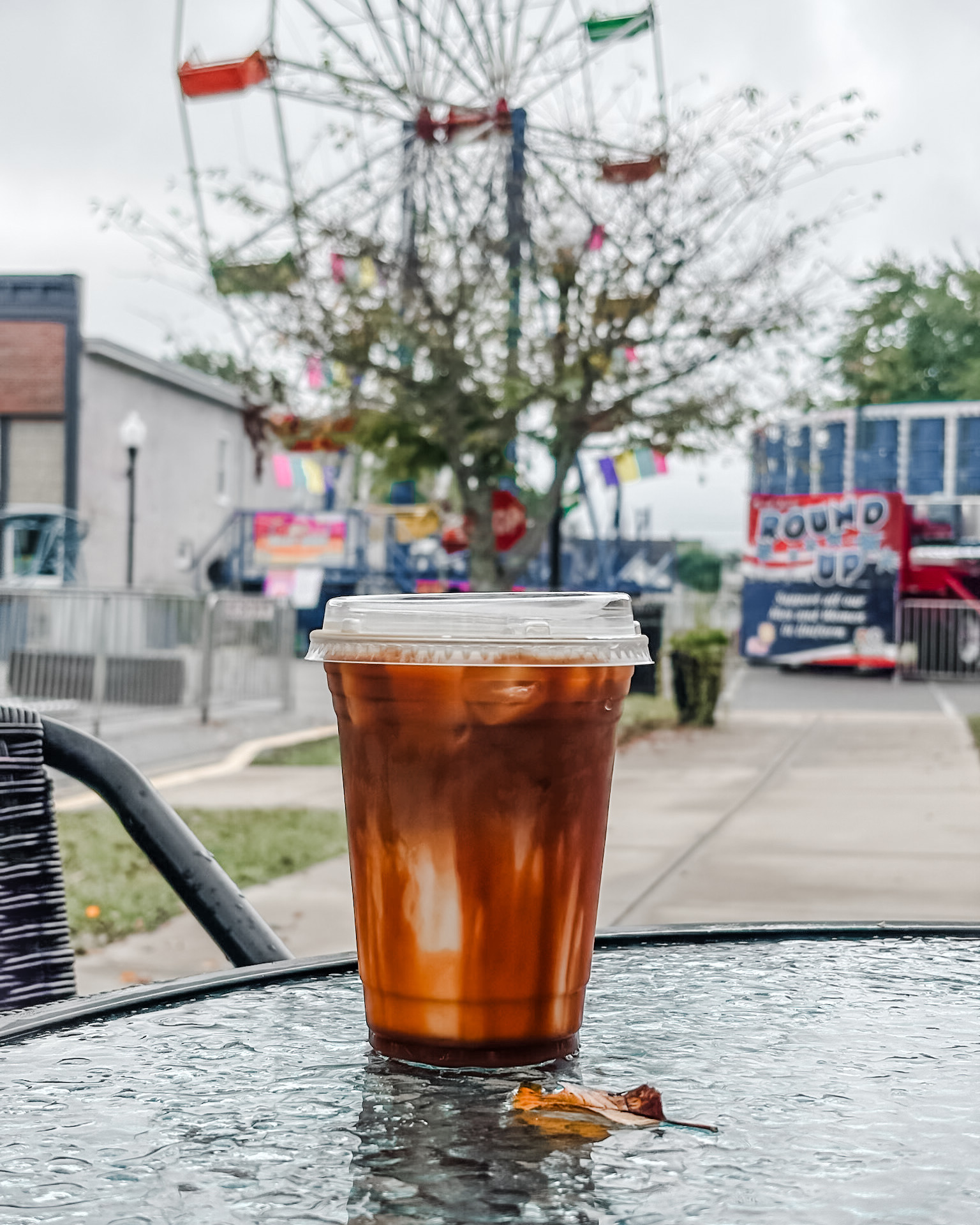 Iced cold brew with cream swirls in front of the town festival