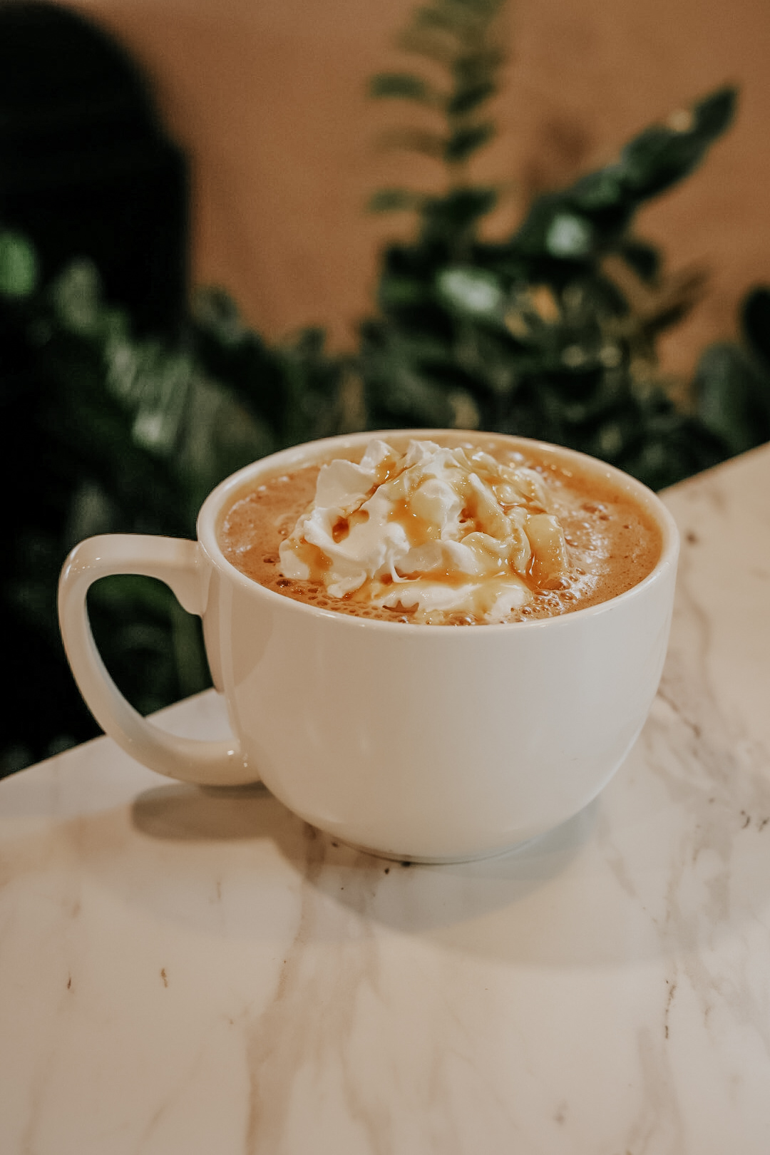 A caramel-topped latte in a white mug